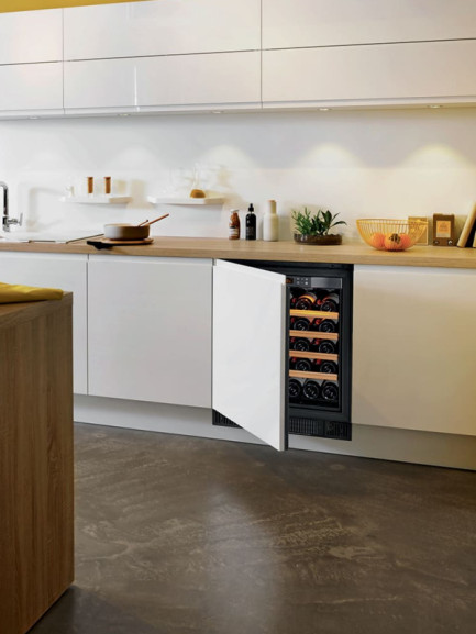 Kleiner, unter einer Arbeitsplatte eingelassener, klimatisierter Weinschrank – undurchsichtige technische Tür mit Montage der Schrankfront. Vollständige UV-Schutztür. Kleiner, unter einer Arbeitsplatte eingelassener, klimatisierter Weinschrank – undurchsichtige technische Tür mit Montage der Schrankfront. Vollständige UV-Schutztür.