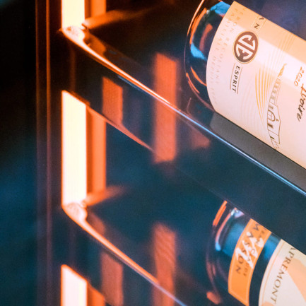 Der leuchtende Heiligenschein, der sich durch den gesamten Weinkhülschrank zieht, zieht die Blicke durch die schöne Hervorhebung der Weinflaschen auf sich. Der leuchtende Heiligenschein, der sich durch den gesamten Weinkhülschrank zieht, zieht die Blicke durch die schöne Hervorhebung der Weinflaschen auf sich.