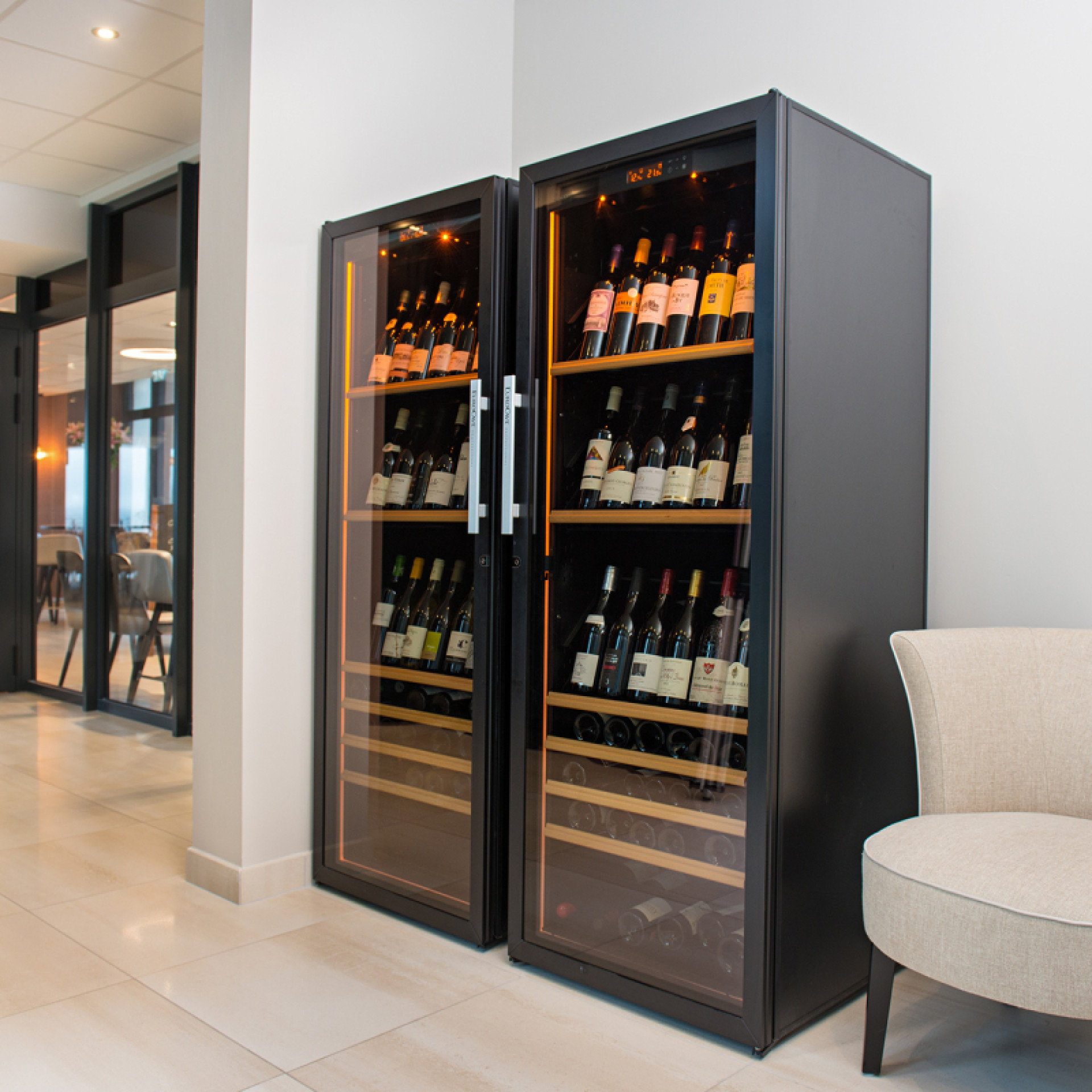 2 Weinkühlschränke, die nebeneinander installiert sind, um die Lagerkapazität von Weinen bei Serviertemperatur zu erhöhen, die zum Verzehr bereit sind.