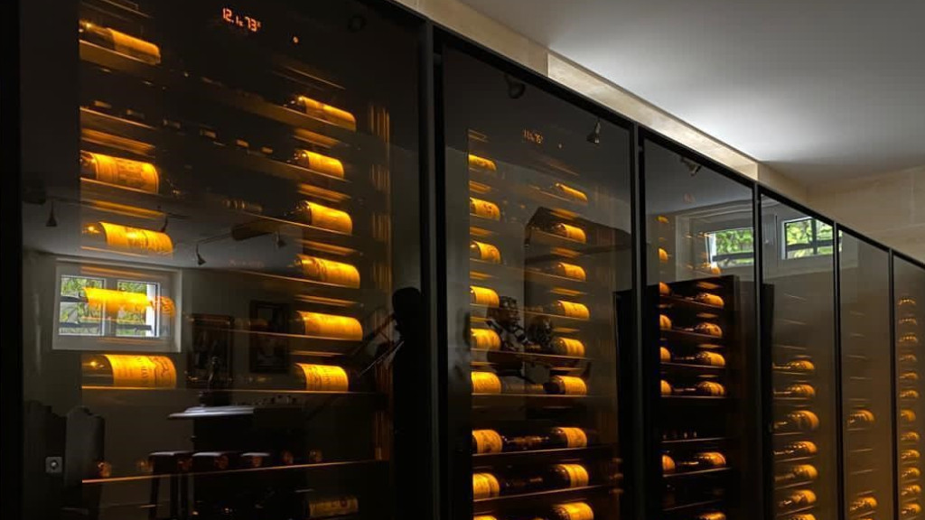 Wand aus luxuriösen Weinschränke mit wunderschöner Flaschenbeleuchtung, die es Ihnen ermöglicht, die Etiketten erlesener Weine deutlich zu erkennen und Ihren Weinkatalog aufzuwerten.