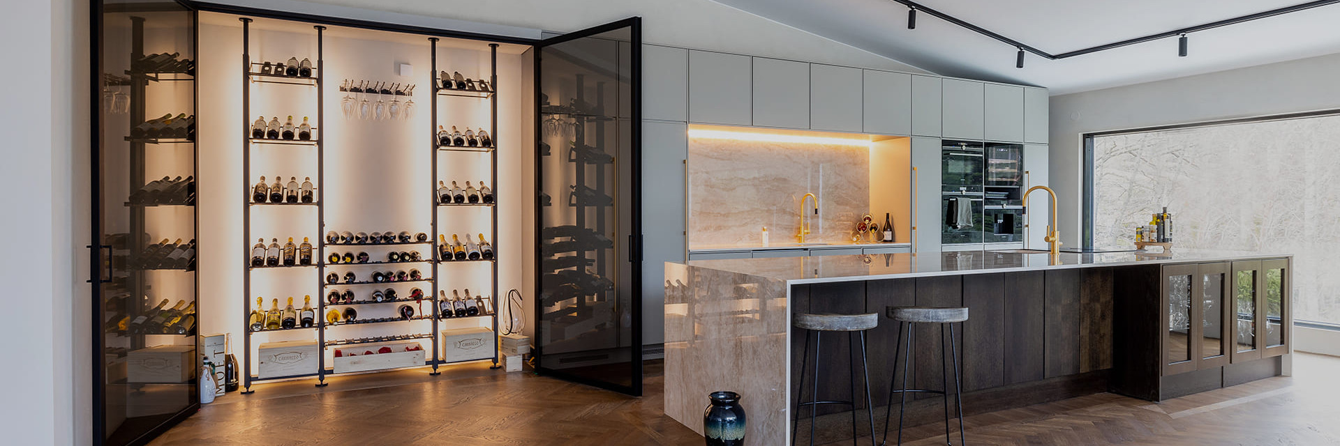 Maßgeschneidertes Innenarchitekturprojekt - Grundriss eines individuellen Weinkellers - Weinkellerbereich mit schwarzen Metallweinregalen, installiert in einer Nische an der Wand einer hochwertigen Küche