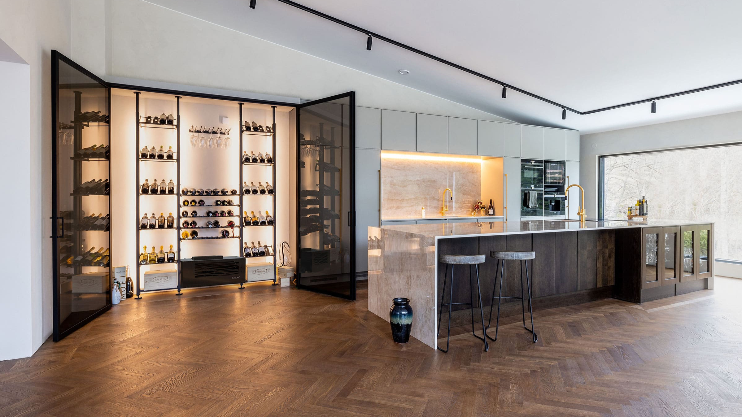 Maßgeschneiderter, klimatisierter Weinbereich. Beispiel für die Herstellung einer Glaswandvitrine in einer Luxusküche. Elegante Innenarchitektur.