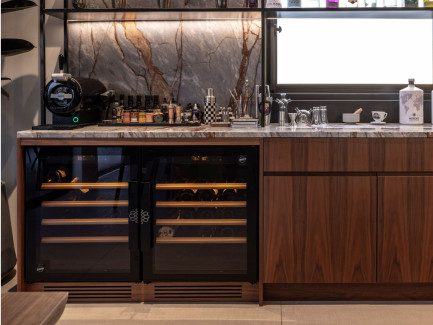 EuroCave-Serie Compact: zwei nebeneinander unter einer Bar installierte Weinschränke mit Marmor-Optik und einem Bereich für Spirituosen.